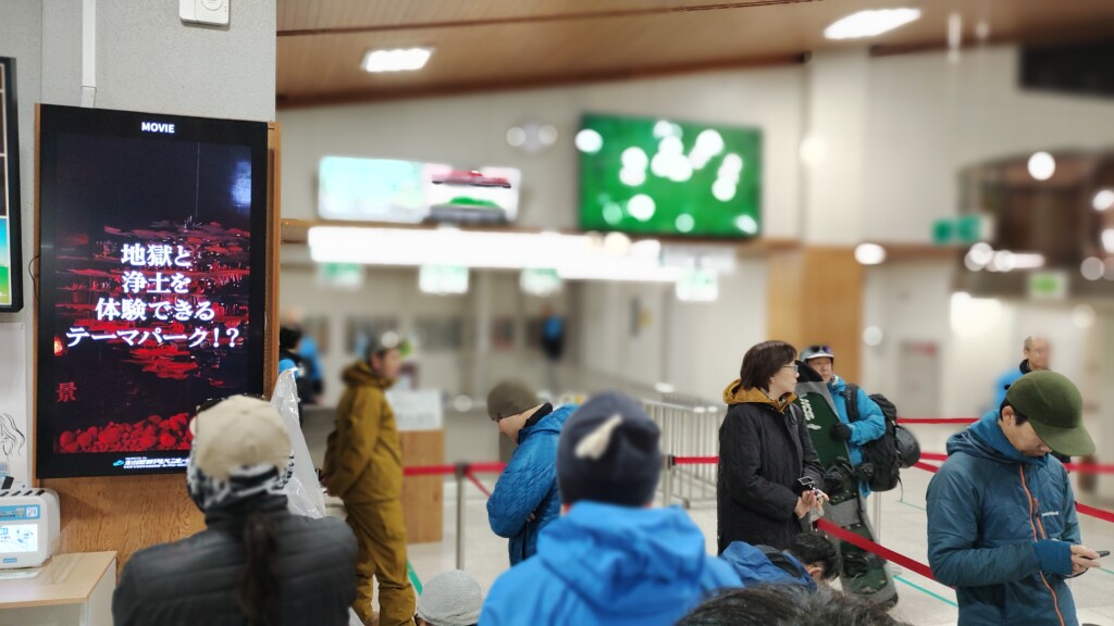 立山駅構内で室堂行きのバスを待っている客達