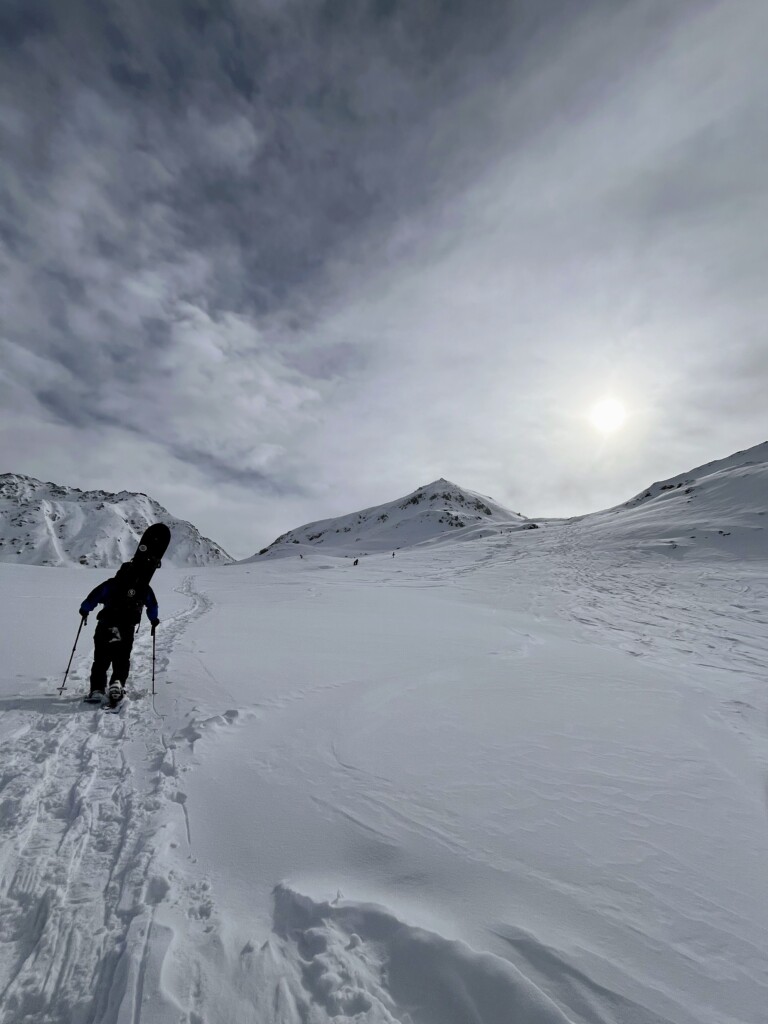 11月の立山でバックカントリースノーボードのため立山の雪斜面をスノーシューで登るスノーボーダーの後ろ姿