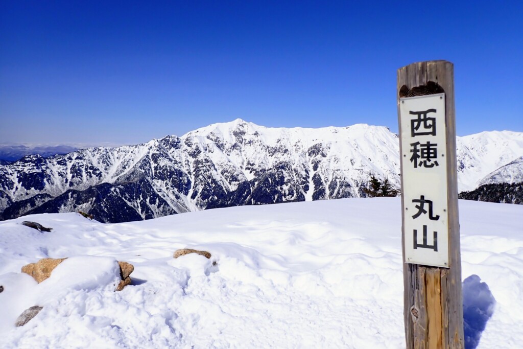 西穂丸山の標識と雪の笠ヶ岳