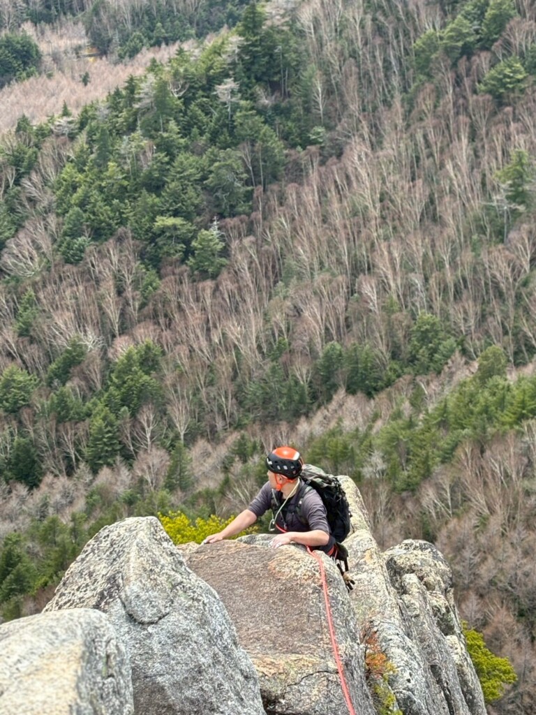 高度感のある岩場でロープをつないで行動するクライマー