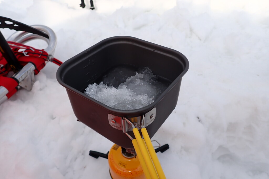 雪上テント泊で鍋に雪を入れて水を作っている様子