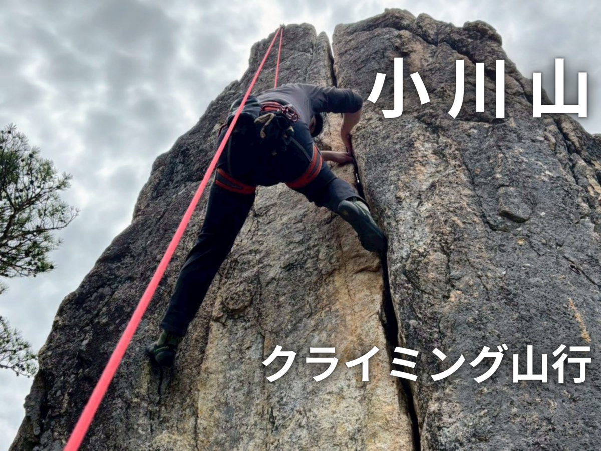 Climber wearing a harness ascends a rocky cliff with a bright red rope; Japanese text '山小川' and 'クライミング山行' overlay the image.