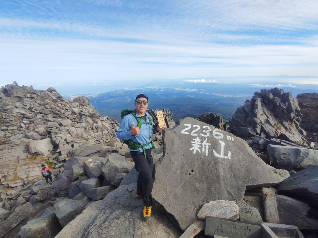 鳥海山最高峰の新山2,236m山頂で記念撮影をする登山者